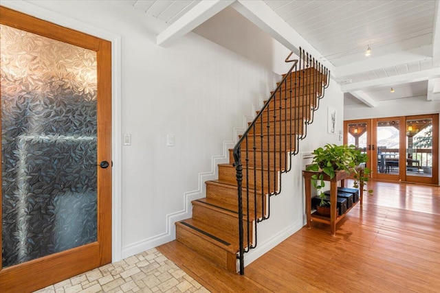 foyer featuring beamed ceiling, french doors, light wood-type flooring, and wooden ceiling