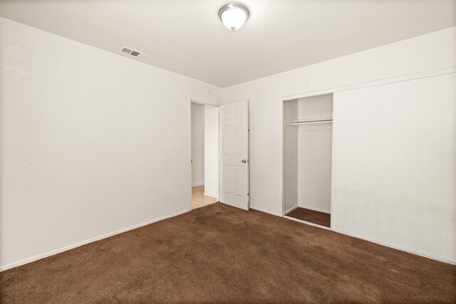 unfurnished bedroom with carpet flooring and a closet