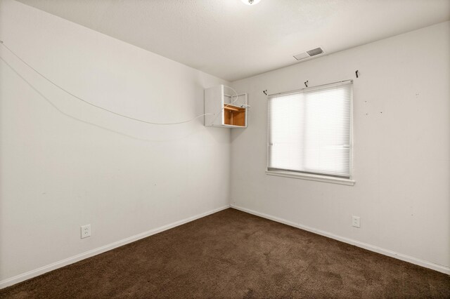 empty room featuring dark carpet