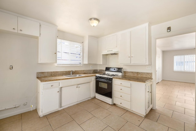 kitchen featuring white cabinetry, sink, light tile patterned floors, and white range with gas stovetop