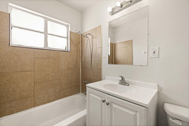 full bathroom with vanity, tiled shower / bath, and toilet