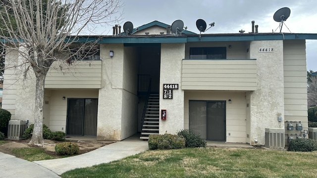 view of property featuring stairway and central AC unit