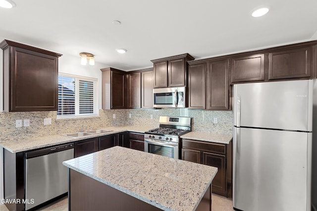 6116 Commonwealth Ave, Bakersfield, CA 93313 - kitchen featuring stainless steel appliances, dark brown cabinetry, backsplash, light stone counters, and recessed lighting