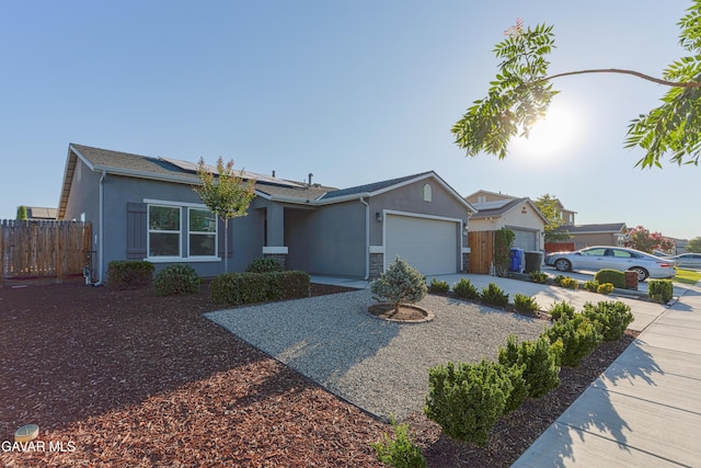 6116 Commonwealth Ave, Bakersfield, CA 93313 - ranch-style house with stucco siding, driveway, a garage, and roof mounted solar panels