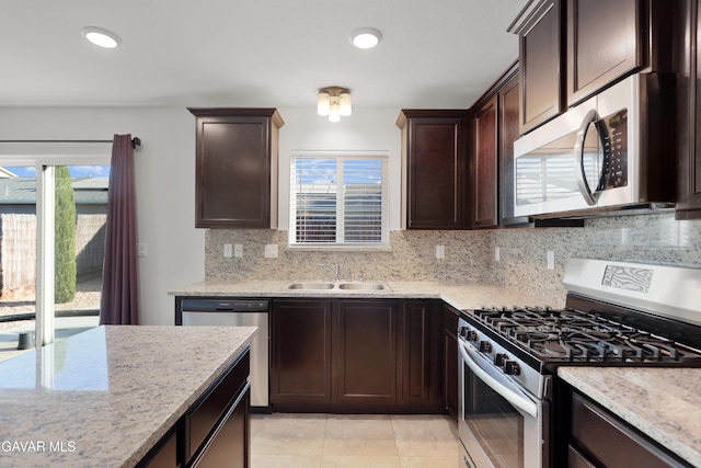 6116 Commonwealth Ave, Bakersfield, CA 93313 - kitchen with appliances with stainless steel finishes, decorative backsplash, dark brown cabinets, light stone countertops, and light tile patterned floors