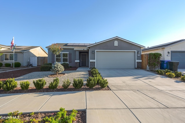 6116 Commonwealth Ave, Bakersfield, CA 93313 - ranch-style home featuring stucco siding, an attached garage, solar panels, driveway, and stone siding