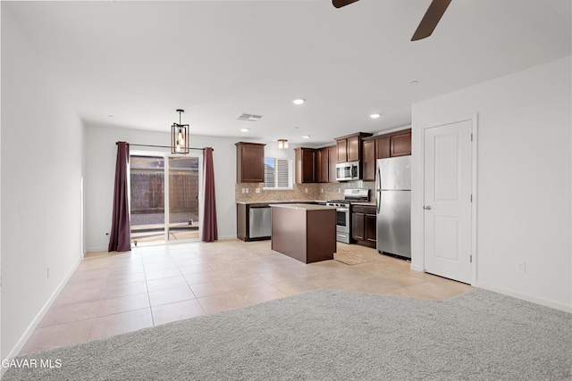6116 Commonwealth Ave, Bakersfield, CA 93313 - kitchen featuring stainless steel appliances, a kitchen island, a ceiling fan, tasteful backsplash, and dark brown cabinets