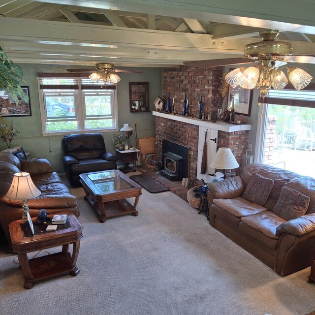 carpeted living room featuring beam ceiling, a wood stove, and ceiling fan