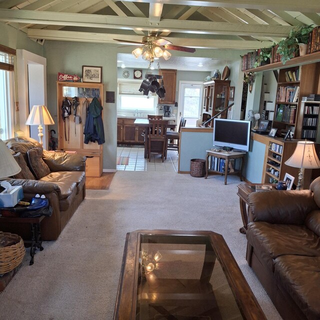 living room featuring ceiling fan, beamed ceiling, and light colored carpet