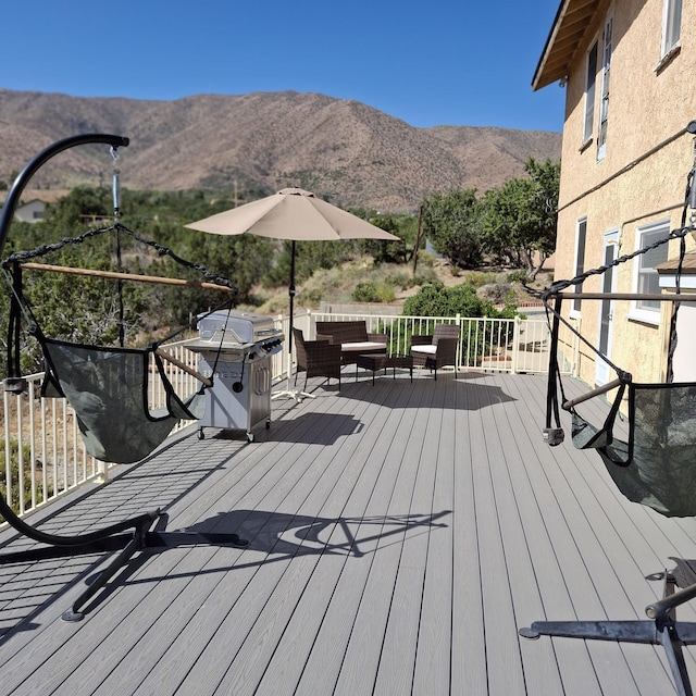 deck featuring a mountain view, an outdoor living space, and grilling area