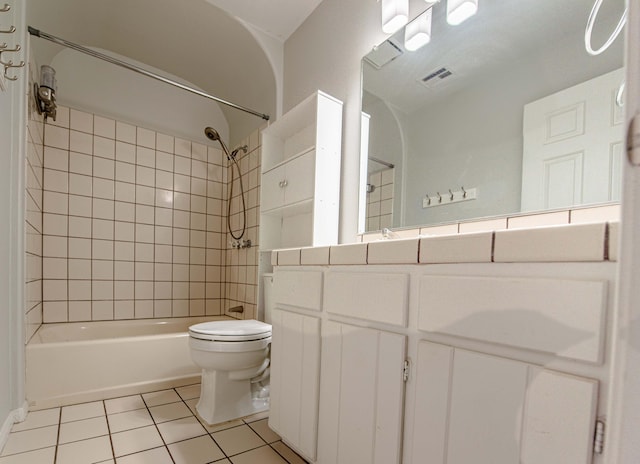 full bathroom featuring toilet, vanity, tile patterned floors, and tiled shower / bath