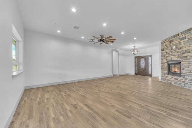 unfurnished living room featuring ceiling fan, a fireplace, and light hardwood / wood-style floors