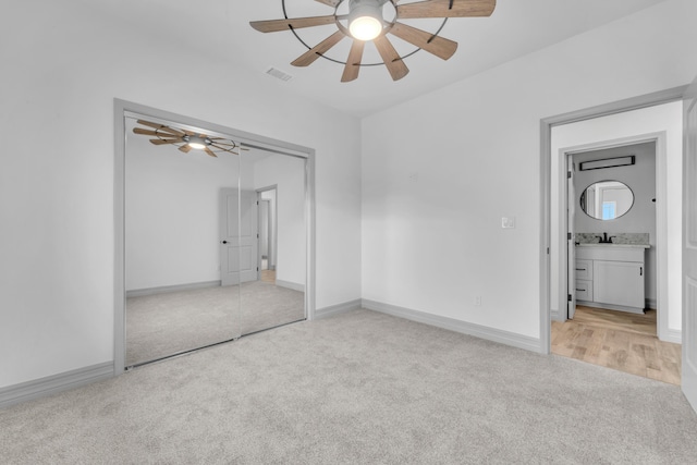 unfurnished bedroom with ceiling fan, a closet, and light carpet