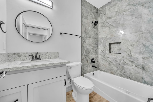 full bathroom with hardwood / wood-style flooring, toilet, vanity, and tiled shower / bath