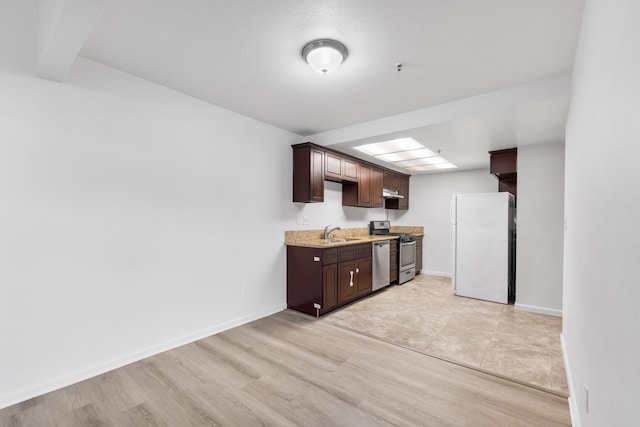 kitchen with sink, dark brown cabinetry, stainless steel appliances, and light hardwood / wood-style flooring