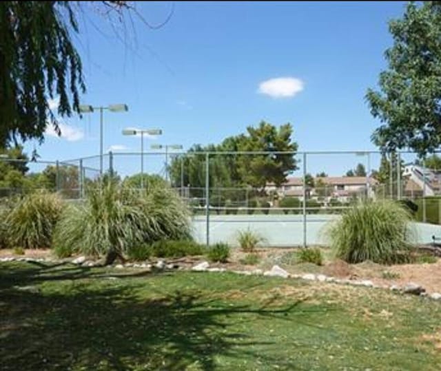 view of sport court with a lawn