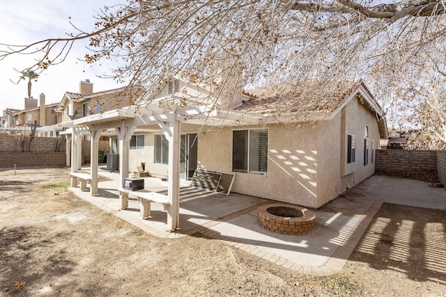 rear view of property featuring a pergola, a fire pit, central AC, and a patio area