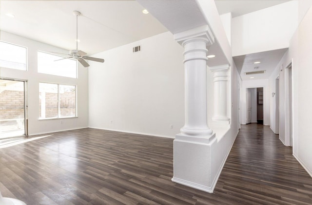 unfurnished living room with dark hardwood / wood-style flooring, ceiling fan, and ornate columns