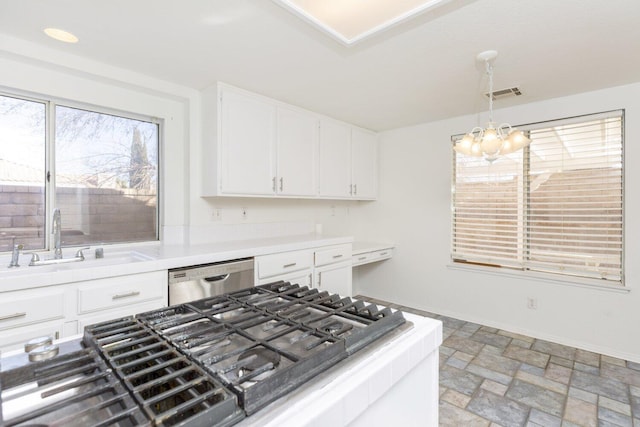 kitchen featuring pendant lighting, sink, white cabinets, stainless steel dishwasher, and a chandelier