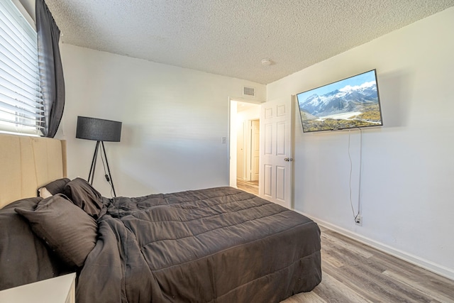 bedroom featuring wood-type flooring and a textured ceiling