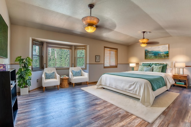 bedroom featuring a textured ceiling, ceiling fan, dark hardwood / wood-style floors, and lofted ceiling