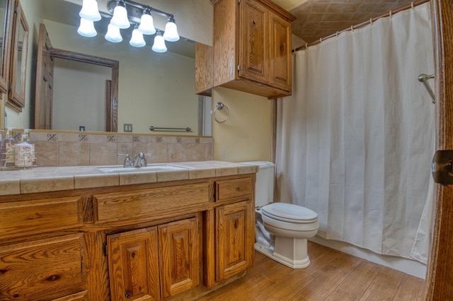 bathroom featuring hardwood / wood-style floors, vanity, toilet, and walk in shower