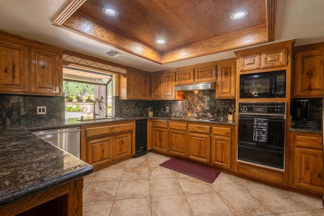 kitchen featuring sink, decorative backsplash, a tray ceiling, light tile patterned flooring, and stainless steel appliances