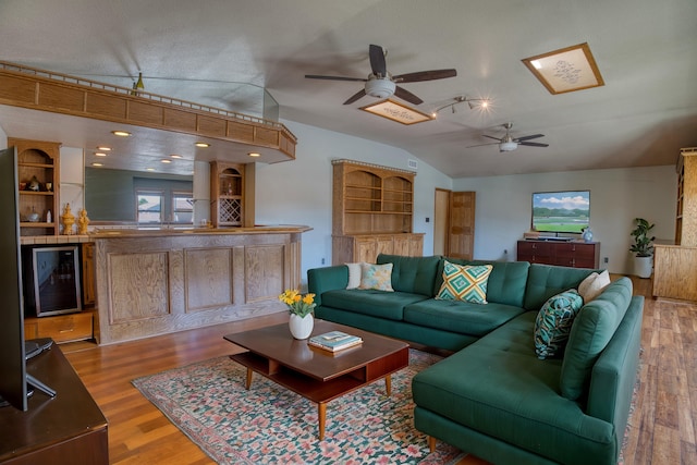 living room with ceiling fan, beverage cooler, lofted ceiling, and wood-type flooring