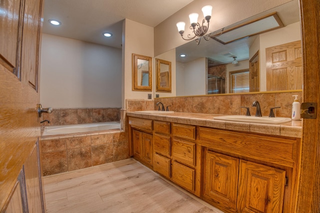 bathroom with vanity, separate shower and tub, wood-type flooring, and an inviting chandelier