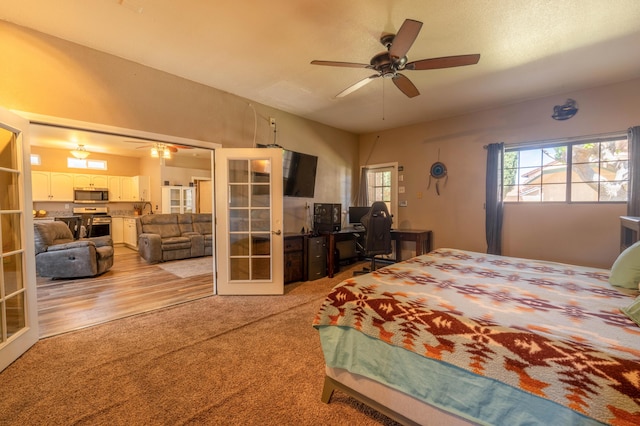 bedroom featuring french doors, light colored carpet, and ceiling fan