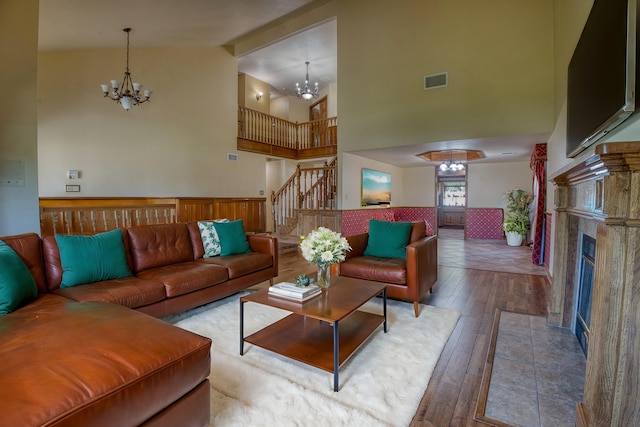 living room featuring hardwood / wood-style floors, high vaulted ceiling, and an inviting chandelier