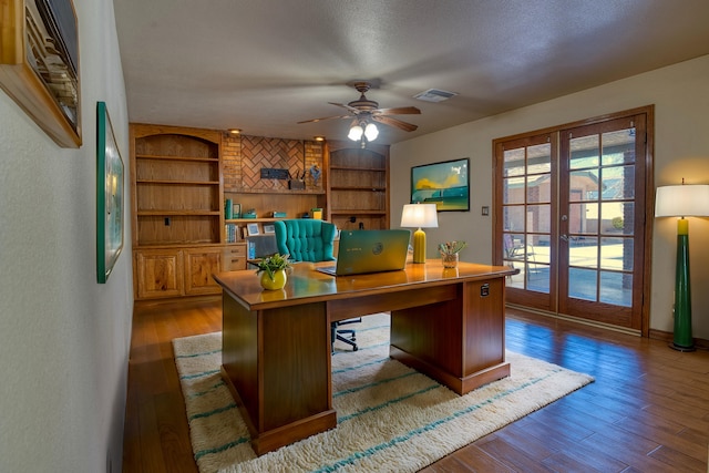 office area featuring built in shelves, ceiling fan, french doors, a textured ceiling, and hardwood / wood-style flooring