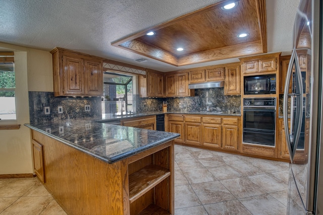 kitchen featuring sink, kitchen peninsula, a tray ceiling, decorative backsplash, and black appliances