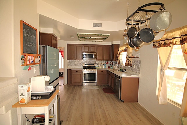 kitchen with visible vents, light wood-style flooring, backsplash, appliances with stainless steel finishes, and light countertops