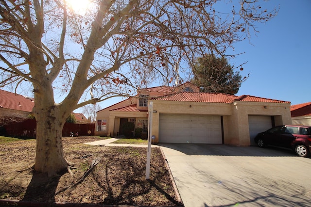 mediterranean / spanish home with stucco siding, driveway, a tile roof, fence, and an attached garage