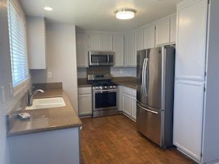 kitchen featuring white cabinets, appliances with stainless steel finishes, a healthy amount of sunlight, and sink