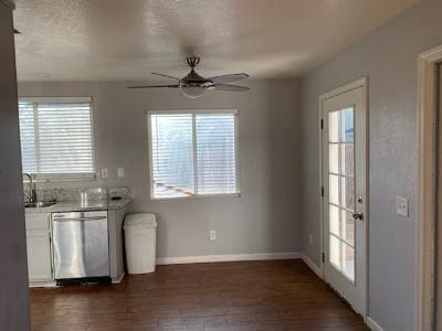 kitchen with white cabinets, stainless steel dishwasher, and a wealth of natural light