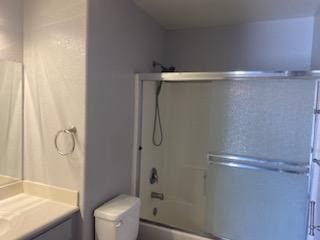 full bathroom with vanity, toilet, and shower / bath combination with glass door