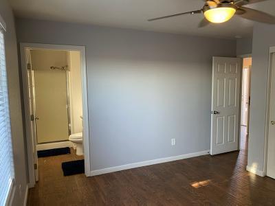 unfurnished bedroom with ensuite bath, ceiling fan, and dark wood-type flooring