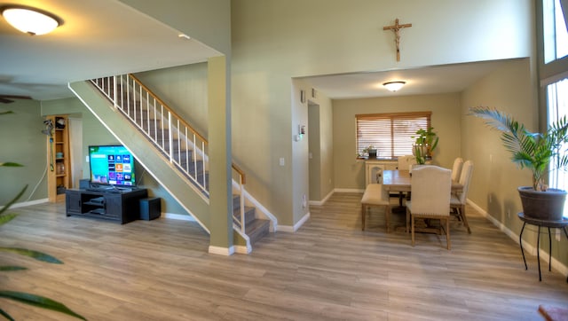 dining area featuring stairs, baseboards, and wood finished floors