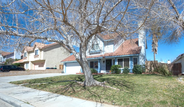 view of front of home featuring a front yard, concrete driveway, fence, and stucco siding