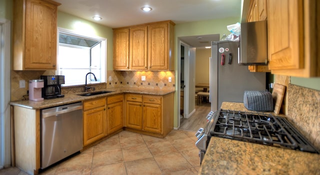 kitchen with light tile patterned floors, recessed lighting, a sink, appliances with stainless steel finishes, and tasteful backsplash