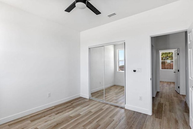 unfurnished bedroom featuring ceiling fan, a closet, and light hardwood / wood-style flooring