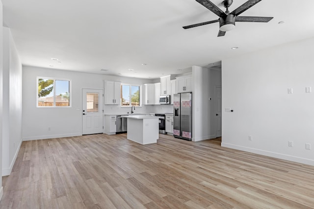 kitchen with white cabinetry, a center island, a healthy amount of sunlight, and appliances with stainless steel finishes