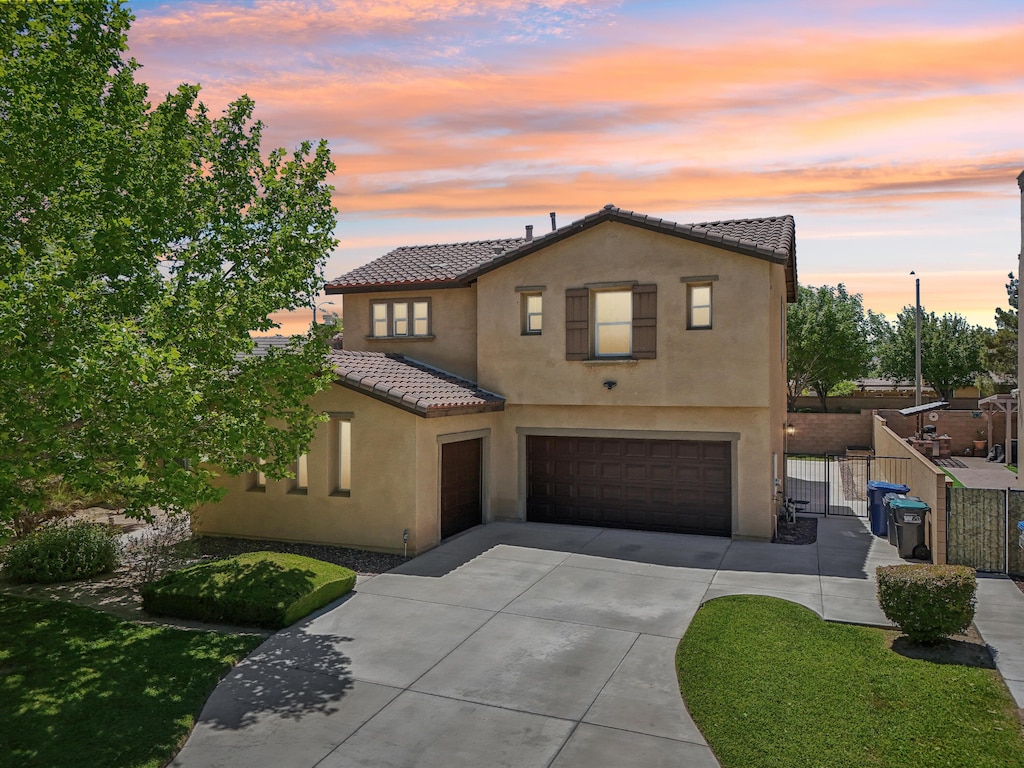 3024 Albret St, Lancaster, CA 93536 - mediterranean / spanish-style home with a garage, a tiled roof, driveway, stucco siding, and fence