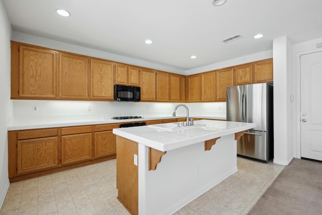 3024 Albret St, Lancaster, CA 93536 - kitchen featuring black appliances, a sink, a kitchen island with sink, brown cabinetry, and recessed lighting