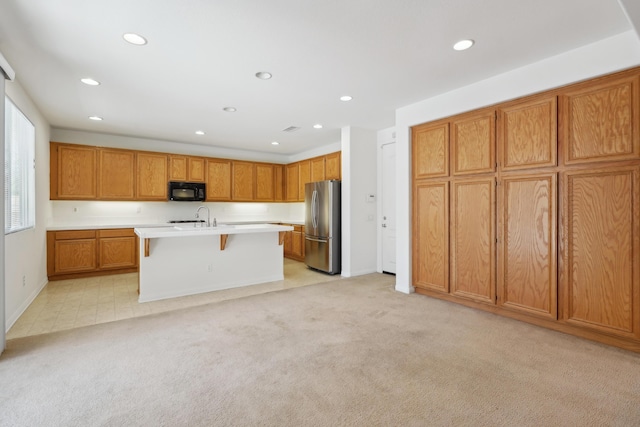 3024 Albret St, Lancaster, CA 93536 - kitchen with freestanding refrigerator, black microwave, recessed lighting, a kitchen breakfast bar, and light countertops