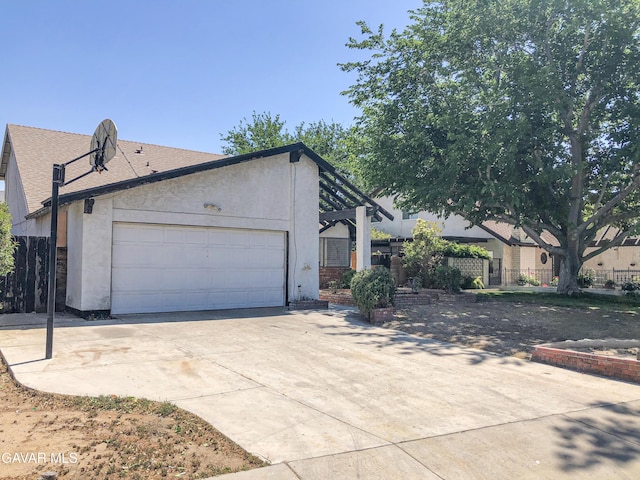 1132 Morven St, Lancaster, CA 93535 - view of side of property featuring concrete driveway, a garage, stucco siding, and roof with shingles