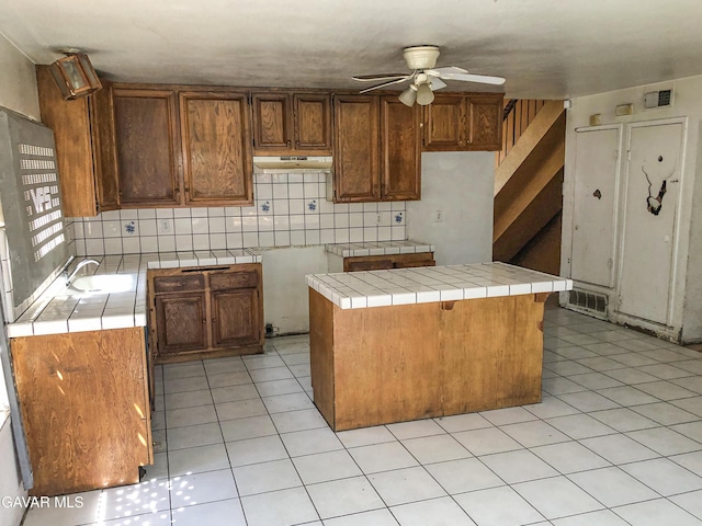 1132 Morven St, Lancaster, CA 93535 - kitchen featuring ceiling fan, tile counters, under cabinet range hood, and light tile patterned floors
