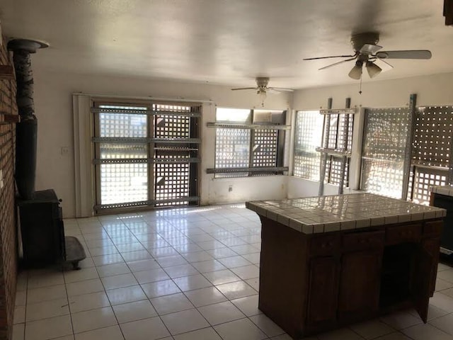 1132 Morven St, Lancaster, CA 93535 - wine area featuring a wood stove, a ceiling fan, and light tile patterned floors